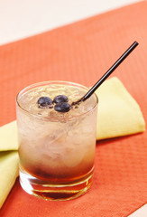 Bramble cocktail in a glass with blueberry