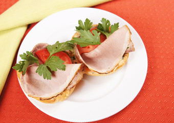 Pair of sandwiches with ham and tomatoes