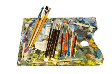 oil painters palette with brushes on white