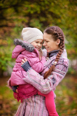 Little girl and her mother in the autumn park