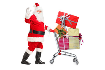 Santa Claus pushing a cart full of presents and waving hand