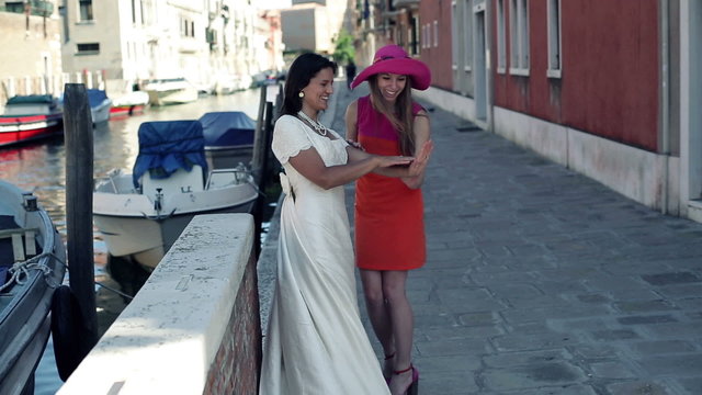 Happy bride showing ring to her bridesmaid in Venice, crane shot