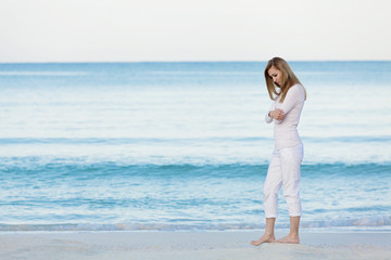 Fototapeta na wymiar Hübsche blonde junge frau entspannt sich alleine am Strand am m