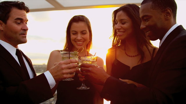 Multi ethnic friends drinking at outdoor cocktail party