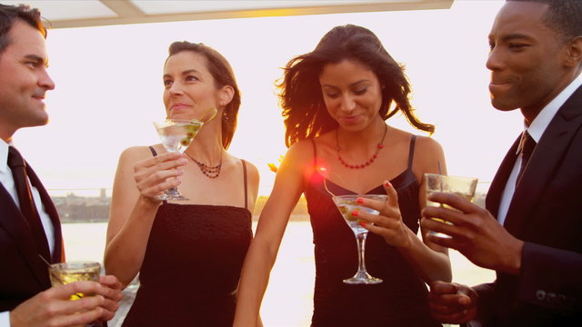 Group of multi ethnic friends chilling and drinking at cocktail party 