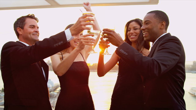 Multi ethnic women and men at cocktail roof party