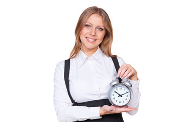 woman holding the alarm clock and looking at camera