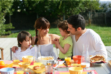 Family having brunch outside on a sunny day