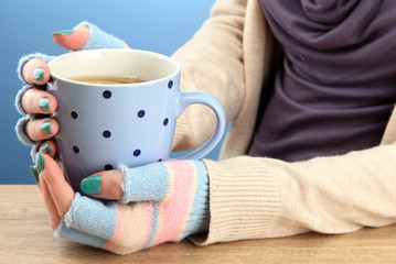 hands holding mug of hot drink, close-up