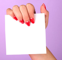 woman's hand holding blank card on color background