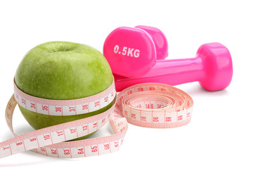 An apple, a measuring tape and dunbbell