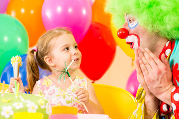 happy child girl with clown on birthday party