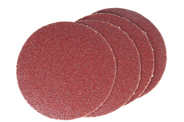 disk of brown sandpaper on a white background.