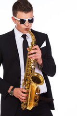 Obraz premium Portrait of handsome man posing on white background with saxopho