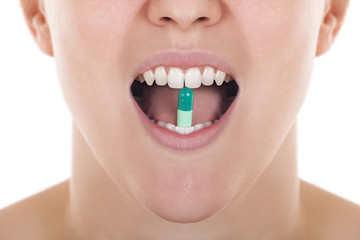 Open mouth with pill between teeth