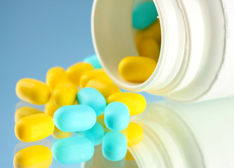 Capsules in bottle, on blue background