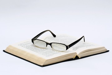 black glasses and book over white