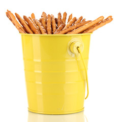 Tasty crispy sticks in yellow pail isolated on white