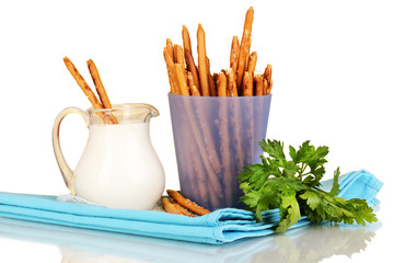 Tasty crispy sticks in purple plastic cup on yellow background