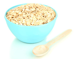 Blue bowl full of oat flakes with wooden spoon isolated on