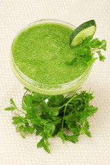 Green vegetable juice in coctail glass on light background