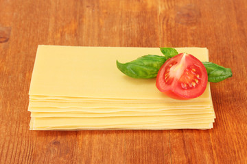 Uncooked lasagna pasta on wooden background
