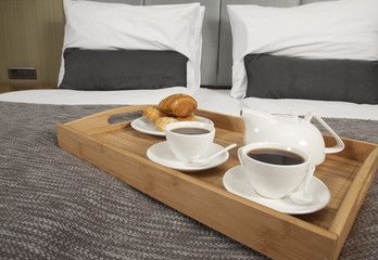 Tray with coffee on a bed in a hotel room
