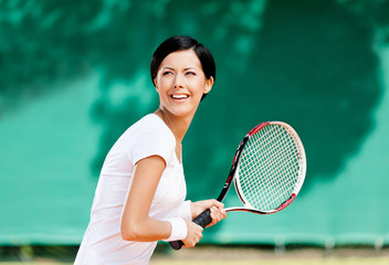 Portrait of successful tennis player with racket