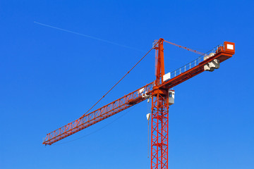 Red construction crane against the blue sky.