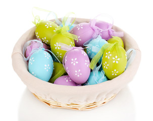 Colorful easter eggs in basket isolated on white