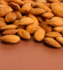 tasty almond nuts, on brown background
