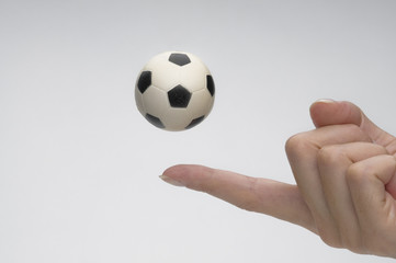 Fototapeta premium Soccer ball with female finger