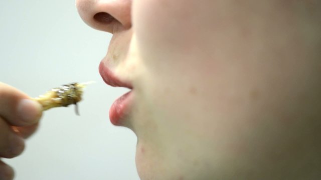 women eats an protein rich grasshopper