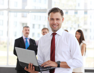Smart business man using laptop with colleagues