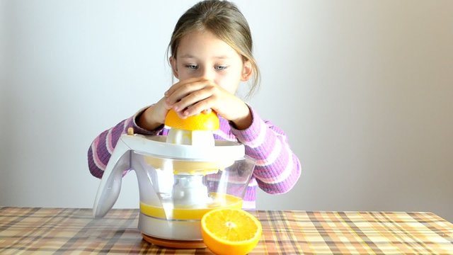 girl making fresh orange juice