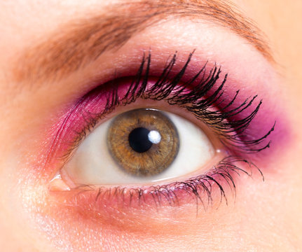 Brown eye with bright pink and violet makeup