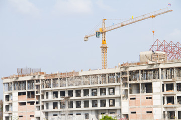 Construction crane at the construction site, on a cloudless sky