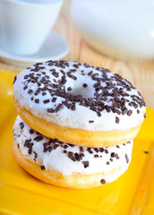 Delicious doughnuts on the yellow plate, donuts with chocolate