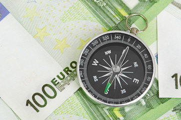 euro bank notes and a compass