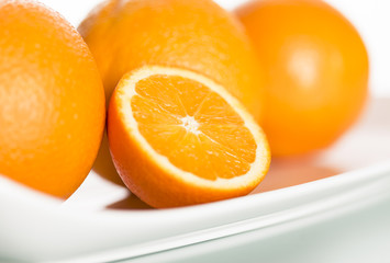Close up of fresh oranges on plate.