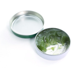 close up of green balm on white background