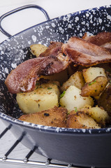 goldbraune Bratkartoffeln mit Speck in einer Pfanne