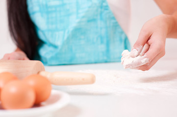 Obraz na płótnie Canvas Woman hands mixing dough on the table