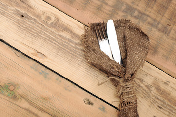 knife and fork in rough old sacking over wood