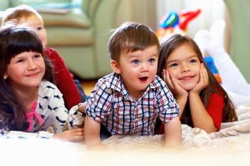 group of happy kids watching tv at home