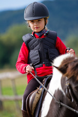 Horse riding - lovely girl is riding a pony