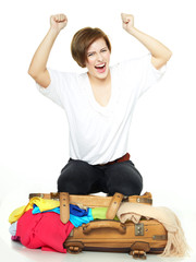 Woman cheers and  packs her overcrowded bag for holiday