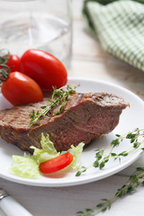 Beef steak with green salad and tomatoes