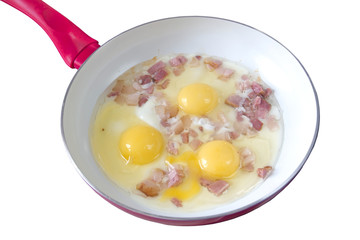 Scrambled eggs with bacon in a frying pan