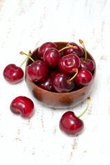 cherries in a bowl on woodensurface